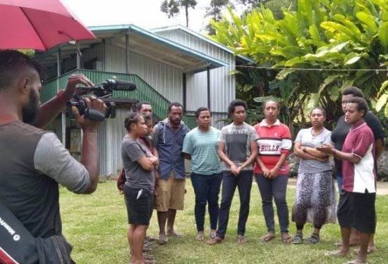 group of people standing together being filmmed